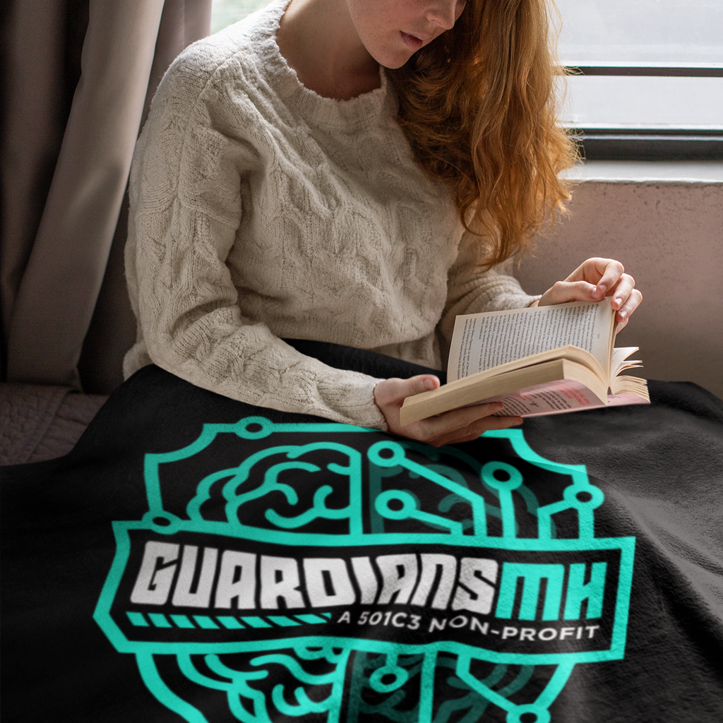 a woman reading a book with a black guardians MH shield throw blanket