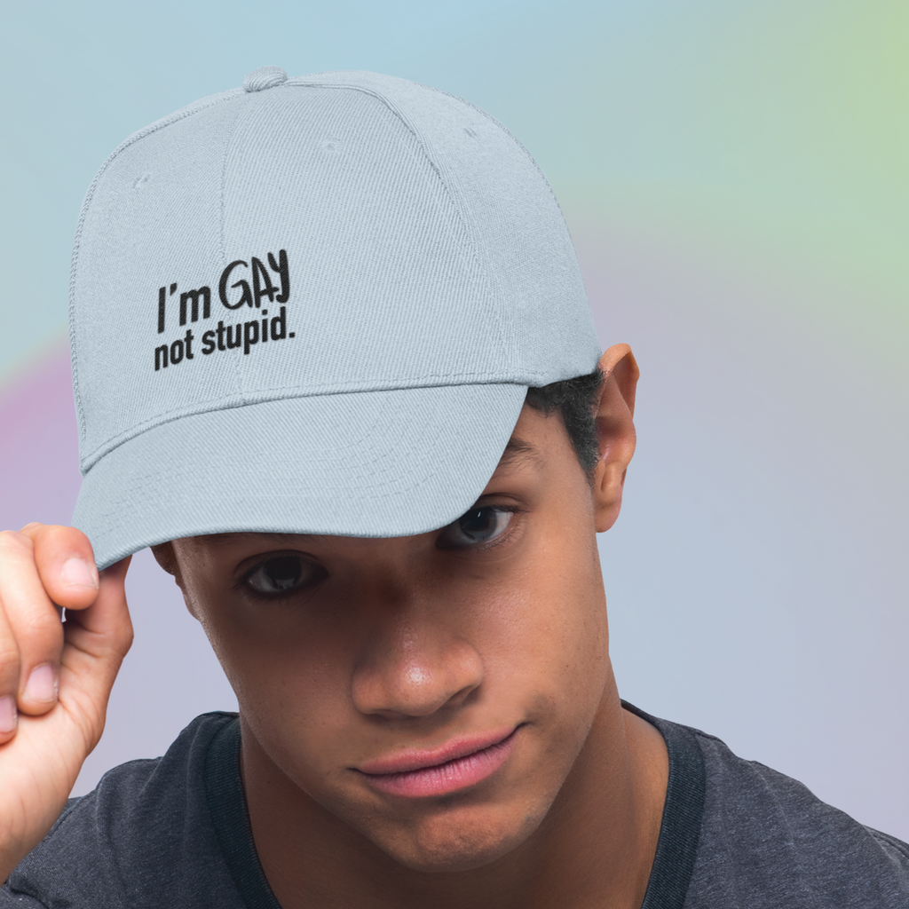 a man wearing a blue dad hat with the I'm Gay Not Stupid design embroidered on it from thezacharymike
