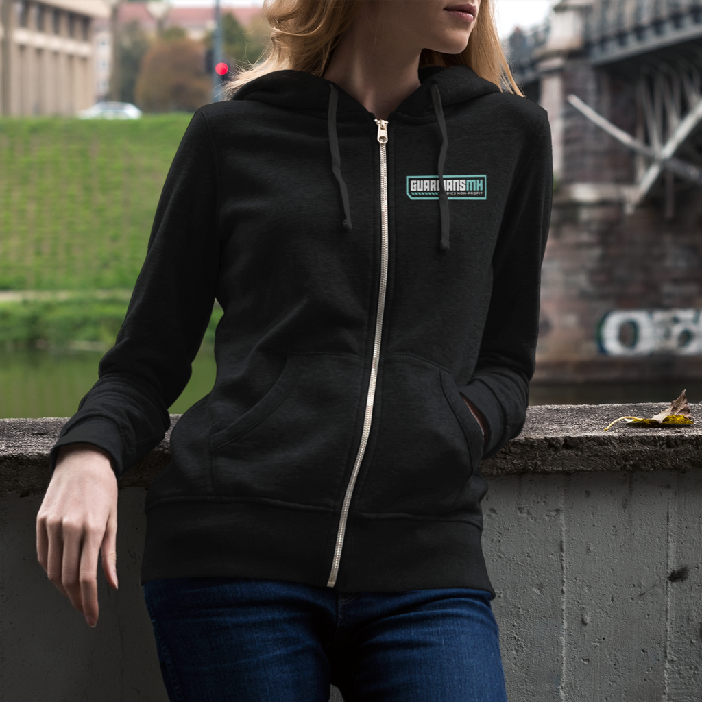 A woman leaning against a bridge wearing a zip hoodie with the guardians MH badge logo on the left chest