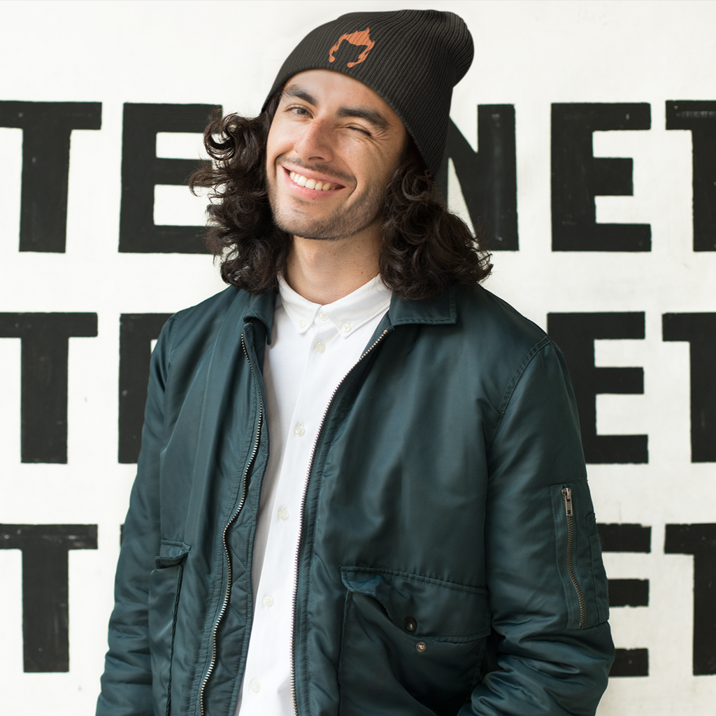 a man with long hair wearing a bomber jacket and a black beanie with the fire kitty embroidered design from diskittysonfire