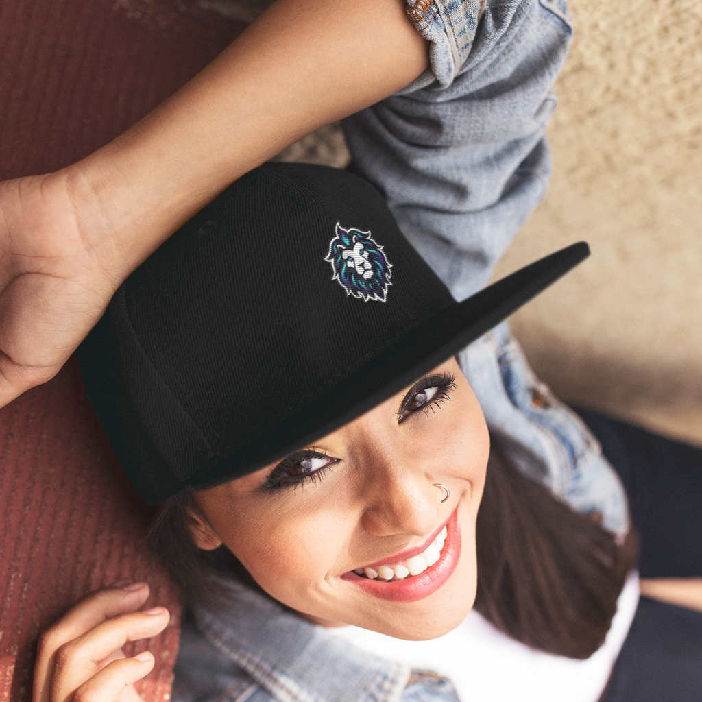 a woman with a nose ring smiling and wearing a black snapback with the leo design from Sandromeda