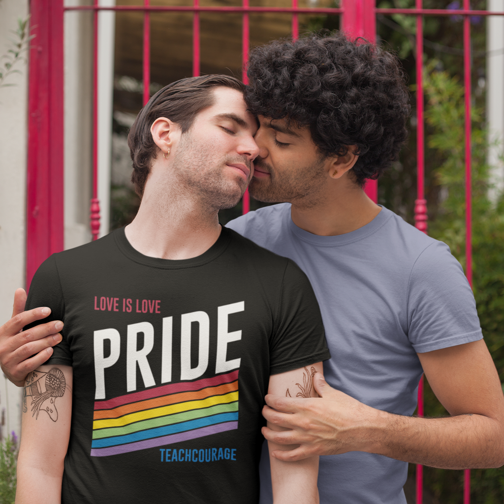 two men embracing, one wearing the pride design from teachcourage