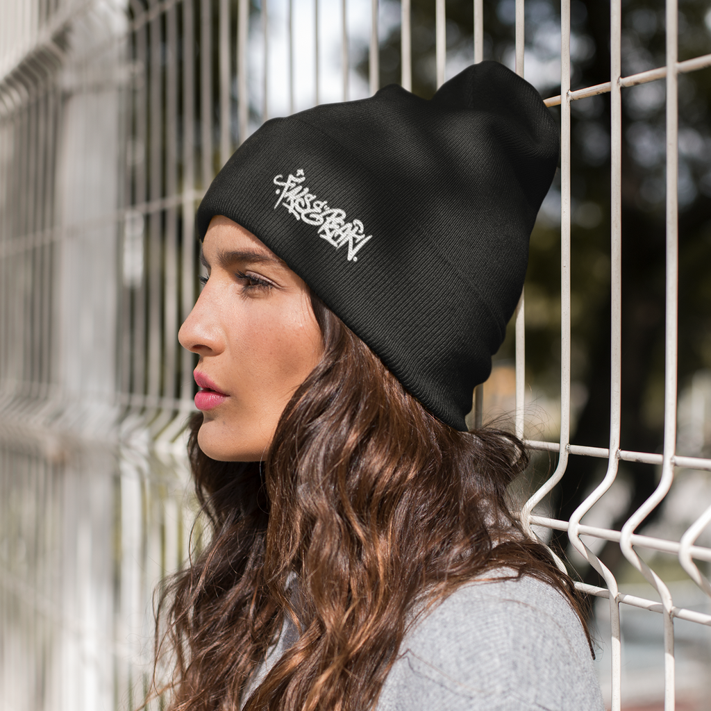 a woman wearing a black beanie with the falsepeak_ graffiti logo embroidered in white