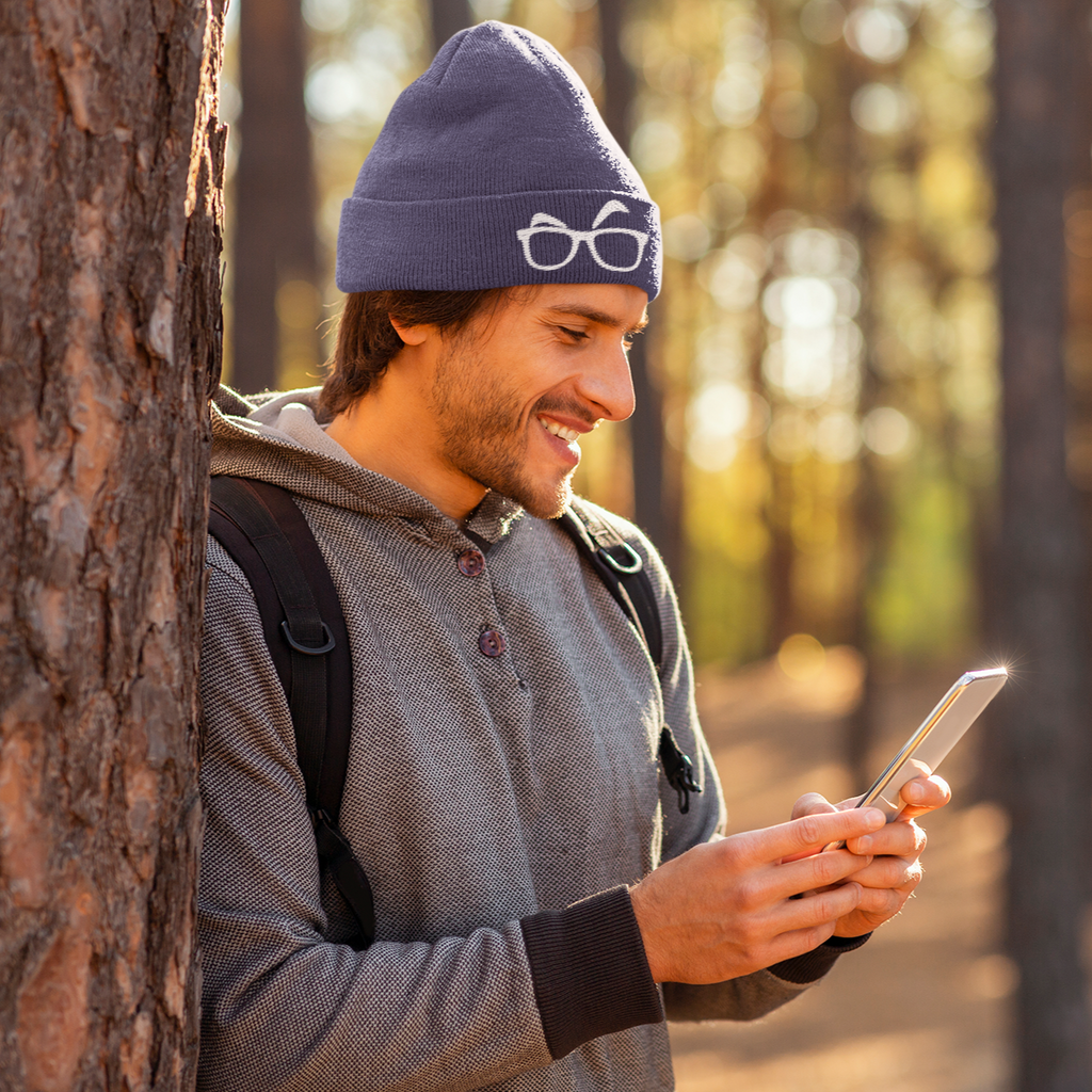 a man in the woods on his phone wearing a TyBrowGames eyebrows beanie
