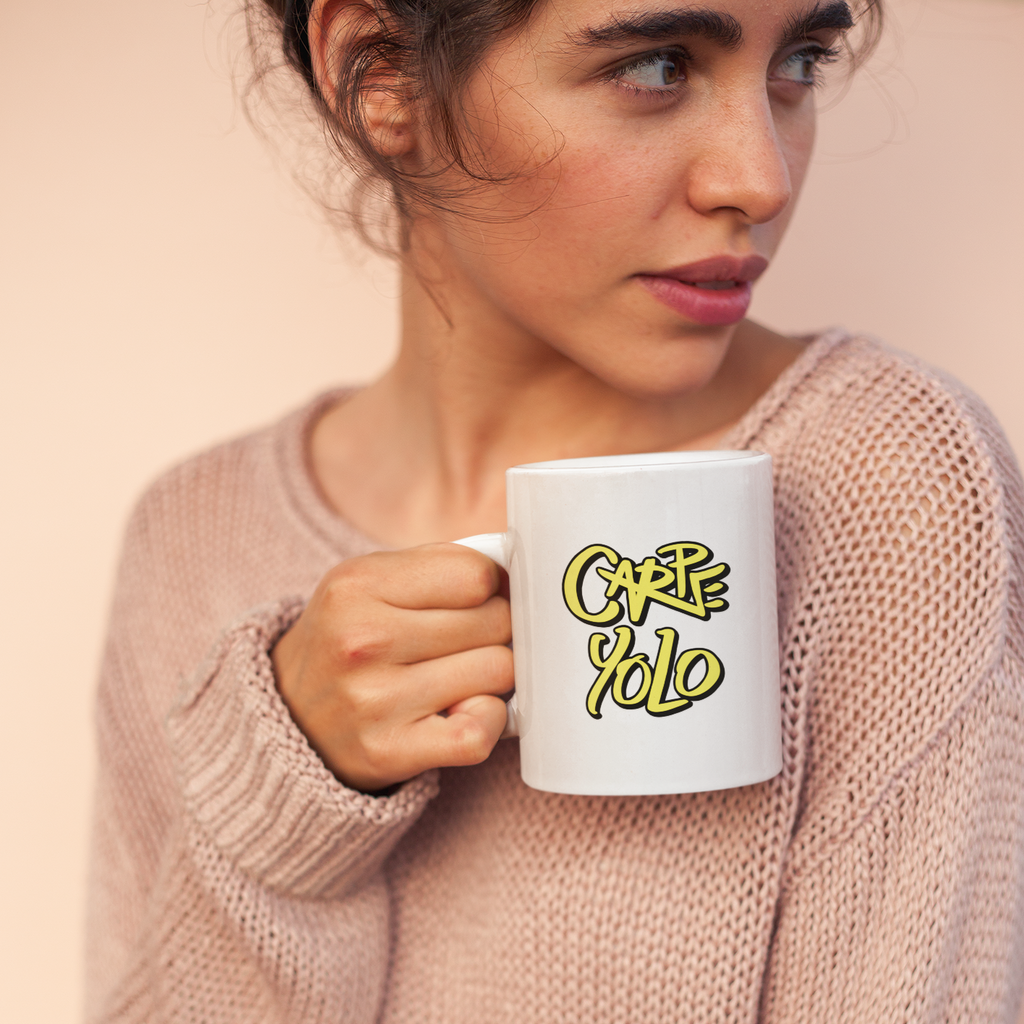 a woman holding a white mug with the carpe yolo design from kevin saxby