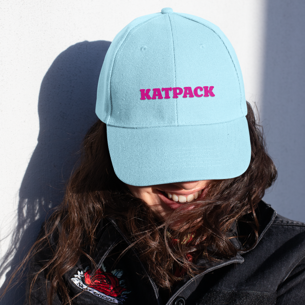 Woman wearing light blue dad hat w/ KatPack wordmark design