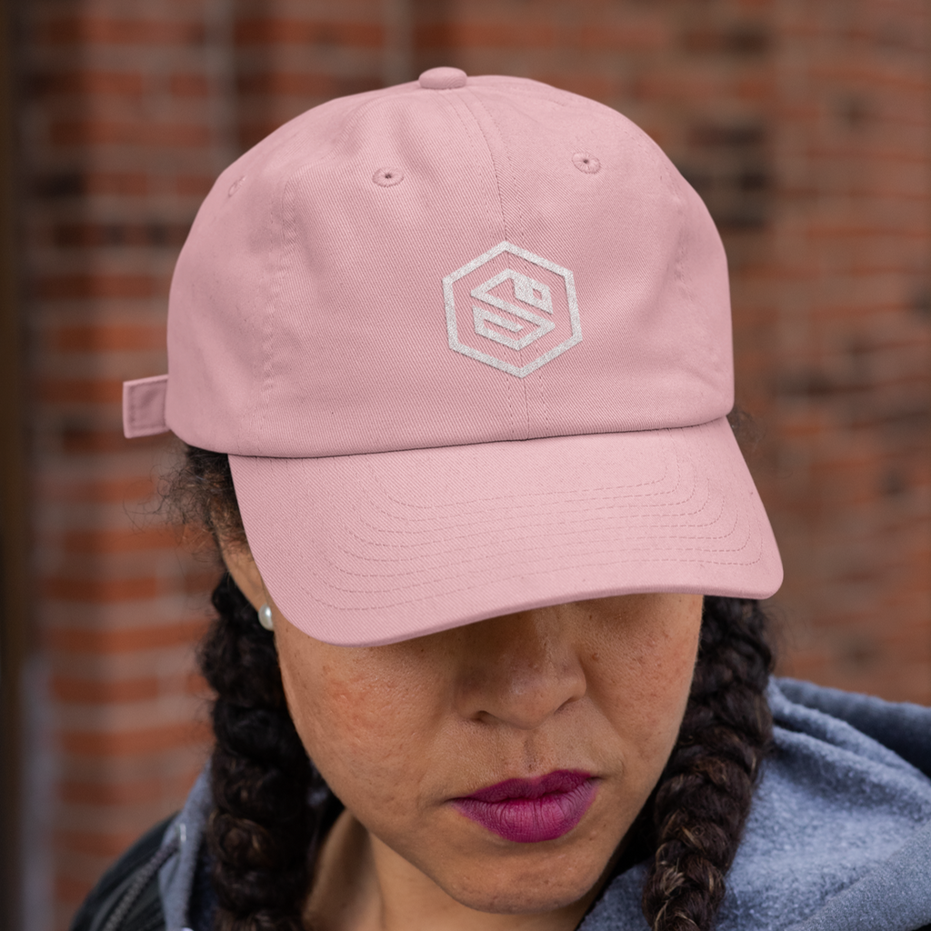 A woman wearing a pink dad hat with the serpentzn logo embroidered on it