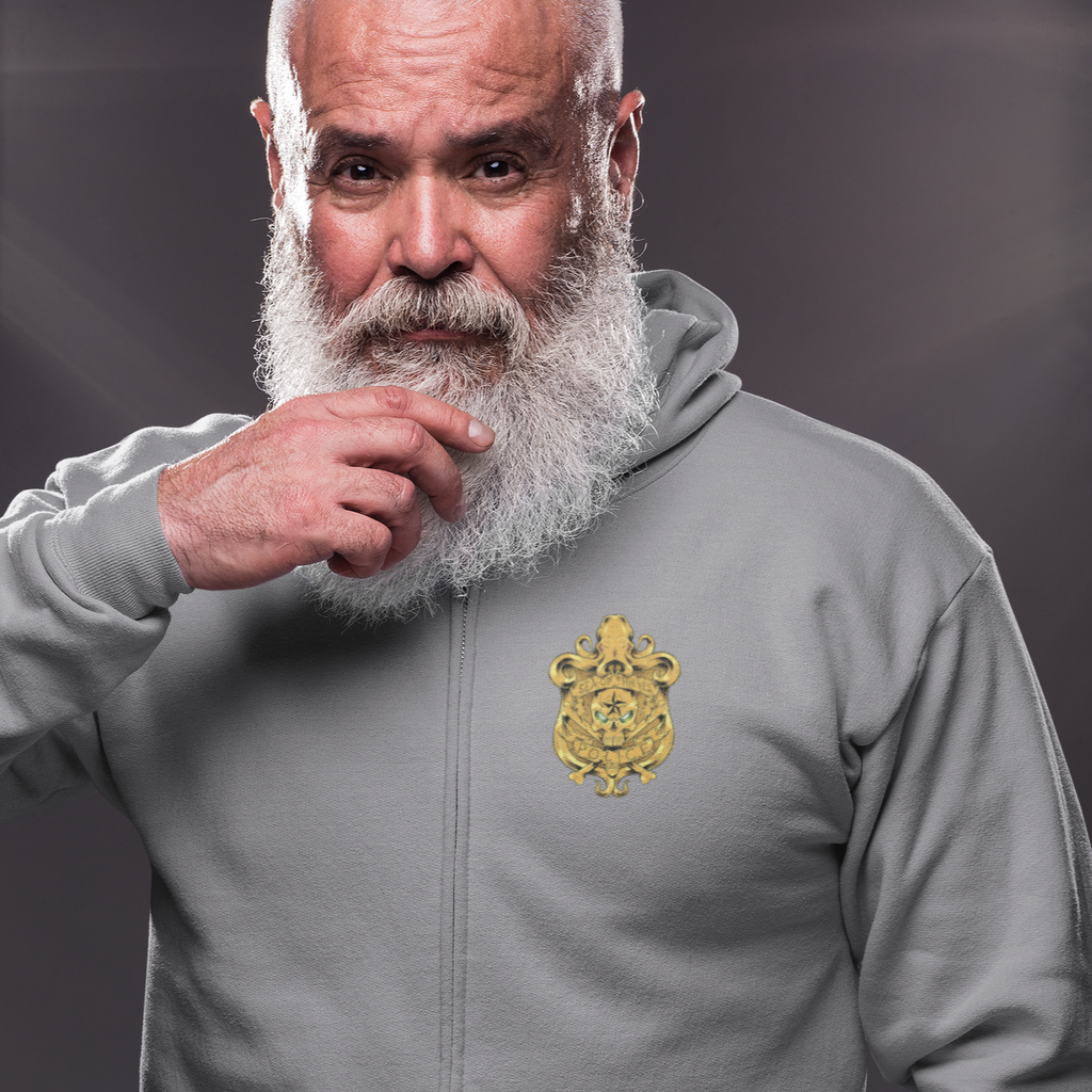 a man with a white beard, wearing a grey zip hoodie with the SOTPD shield on the chest from LetsDrewThis