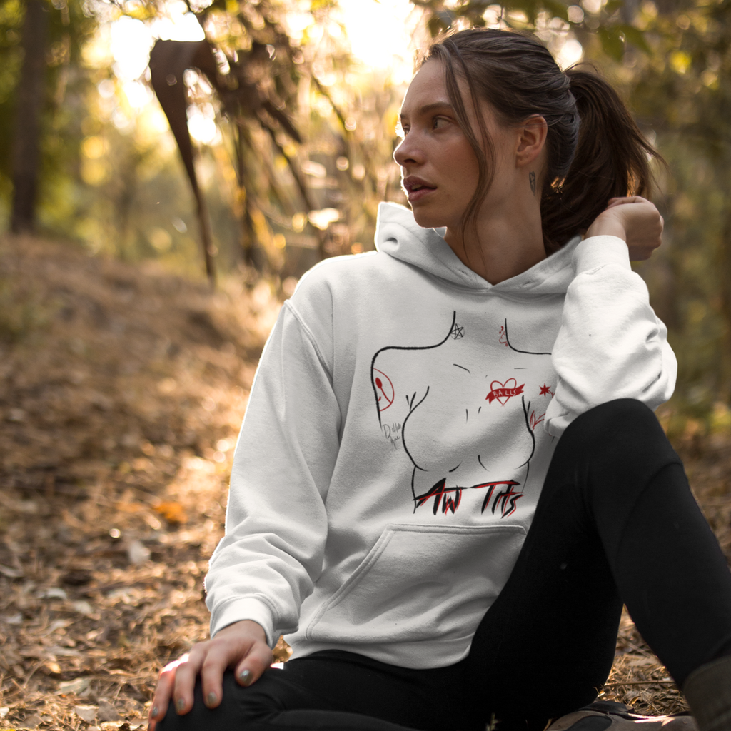 a woman sitting in the woods wearing a white hoodie with the aw tits design from gingersnaps67