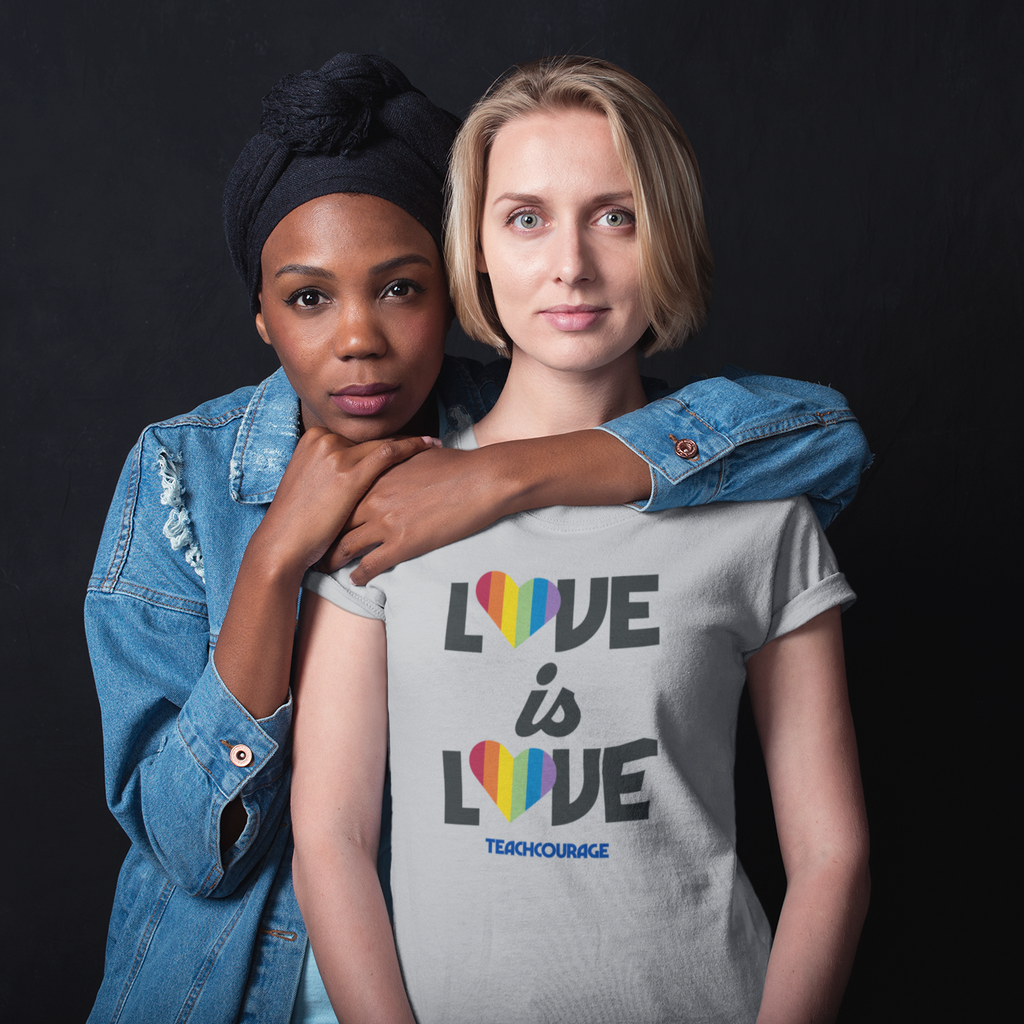 two women embracing, one wearing an athletic heather tshirt with the love is love design from teachcourage