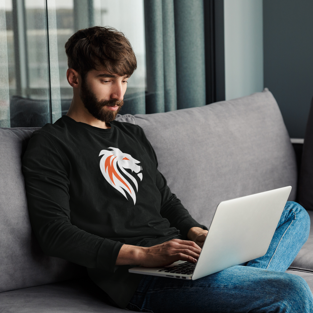 Man working on computer and wearing black long-sleeve tee with xSHUMBAx white lion design