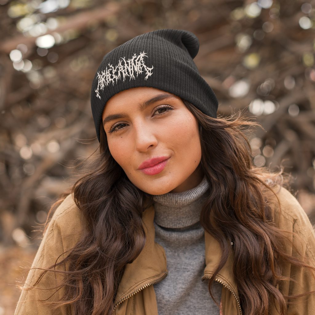 a woman wearing a jacket and a black beanie with the metal logo from ArielAnna