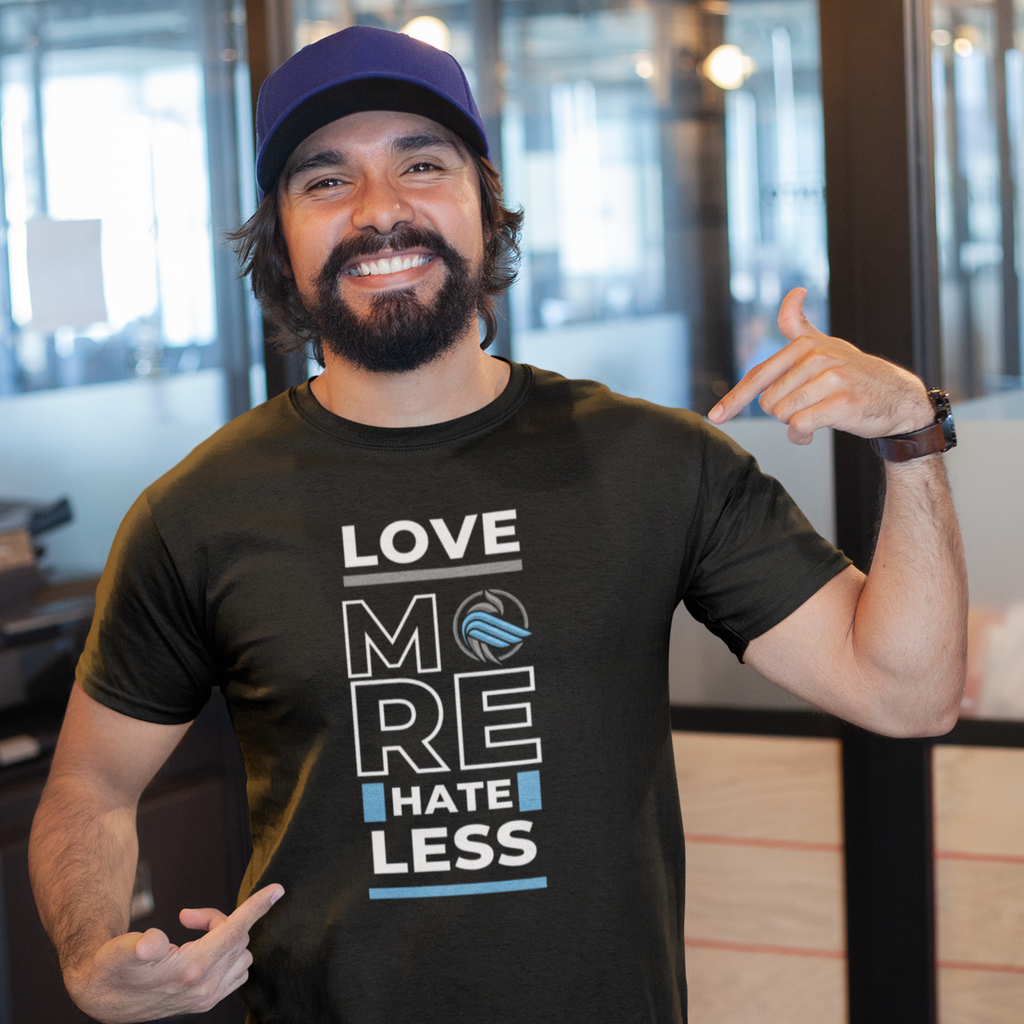 man wearing a hat and a black love more hate less tshirt from aBlackSparrow.  The man is pointing at the design on his shirt.