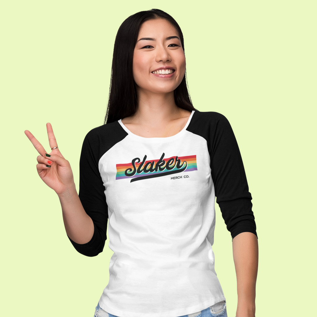 a woman wearing a black and white raglan with the Slaker Merch Pride logo