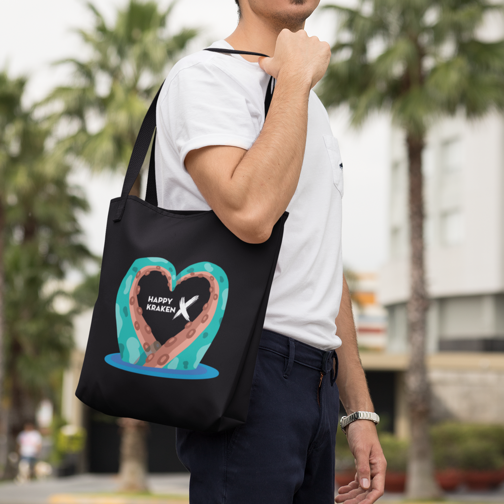 Man holding black tote bag w/ Kraken Heart design