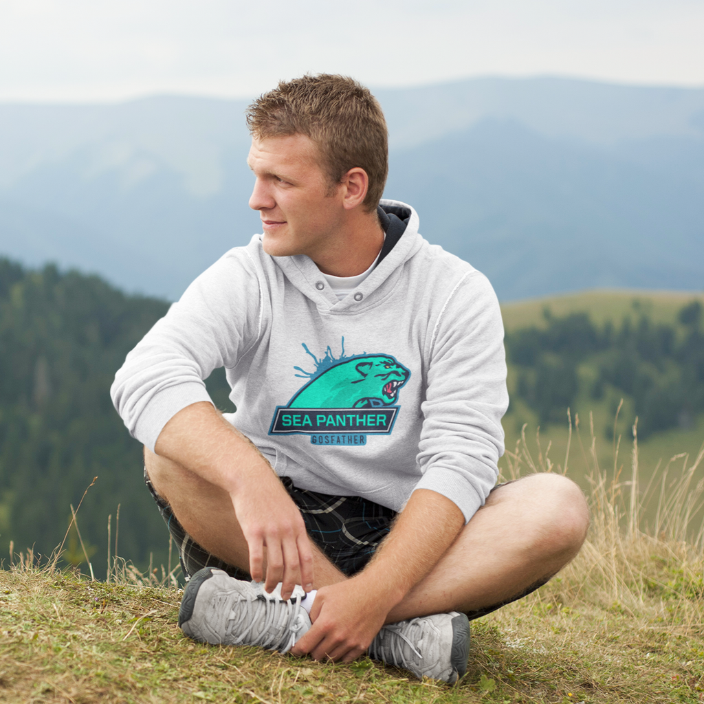 a man sitting in grass with mountains in the background.  He's wearing a white hoodie with the sea panther design from gosfather