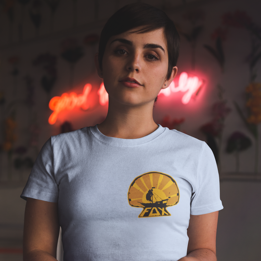 A woman with short hair wearing a blue foxdie sunset tshirt