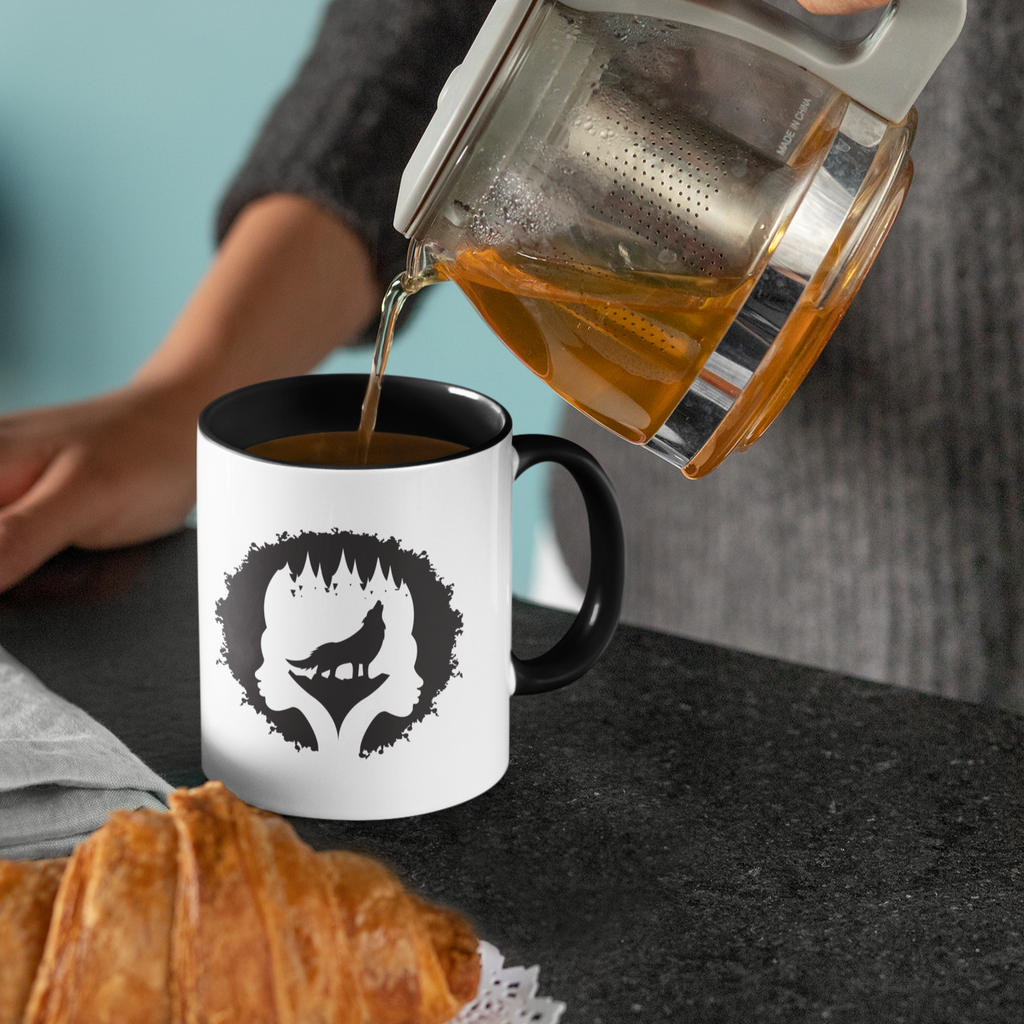 Person pouring tea into black/white mug with Moecahontas logo design