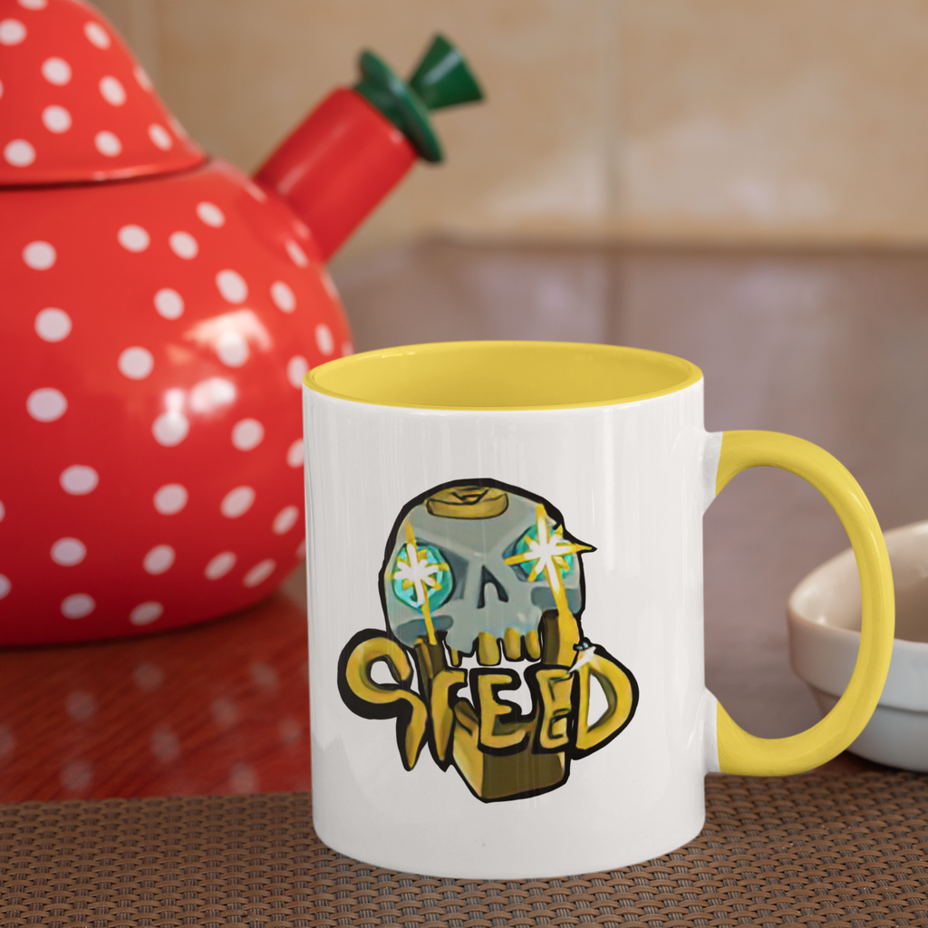 foxdie greed mug with yellow handle and yellow rim in front of a tea kettle