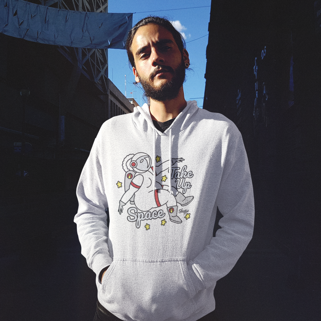 a man standing in an alley way wearing a white hoodie with the take up space design from shae206
