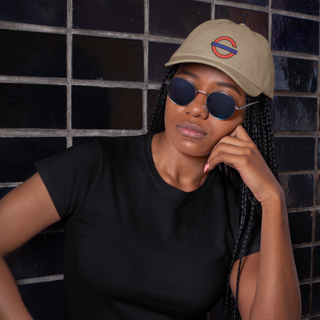a woman with sunglasses wearing a kakhi dad hat with the Gosfather Logo design.