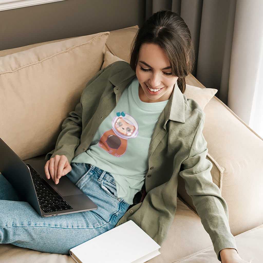 woman sitting on a couch with a laptop wearing a heather mint tshirt with the Fred Bezos design