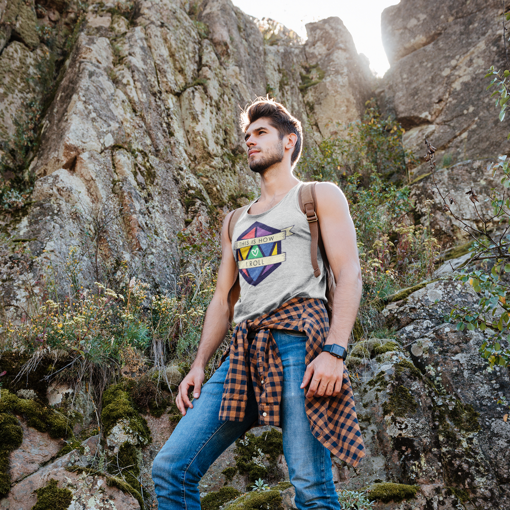 a man hiking in the mountains wearing an athletic heather tank top with the pride D20 design from CalyxCreative
